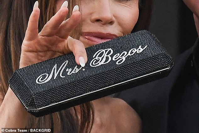 The former journalist paired this look with a black jewel-encrusted clutch bag which read: 'Mrs. Bezos' with clear diamonds as she showed off her new status to the world
