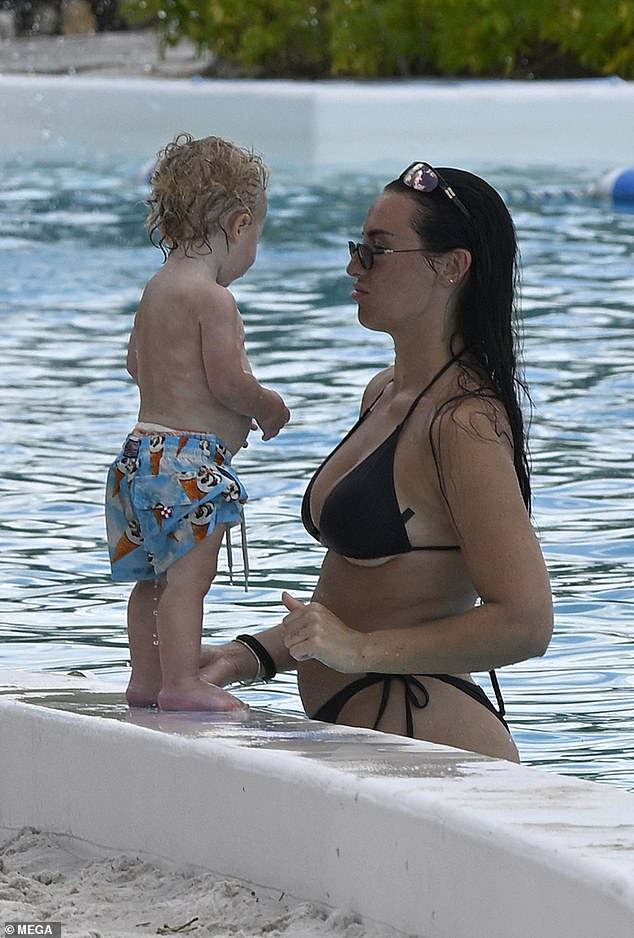 With plans to divorce now in the past, the couple were seen chatting while at the pool with their kids - Roman, 12, Riaan, eight, Reign, six and five-month-old Rezon (pictured with Annie)