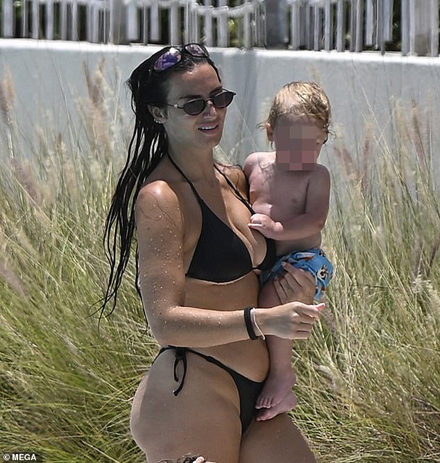 Annie looked every inch the doting mother as she cradled her baby son Rezon during the sweet day out