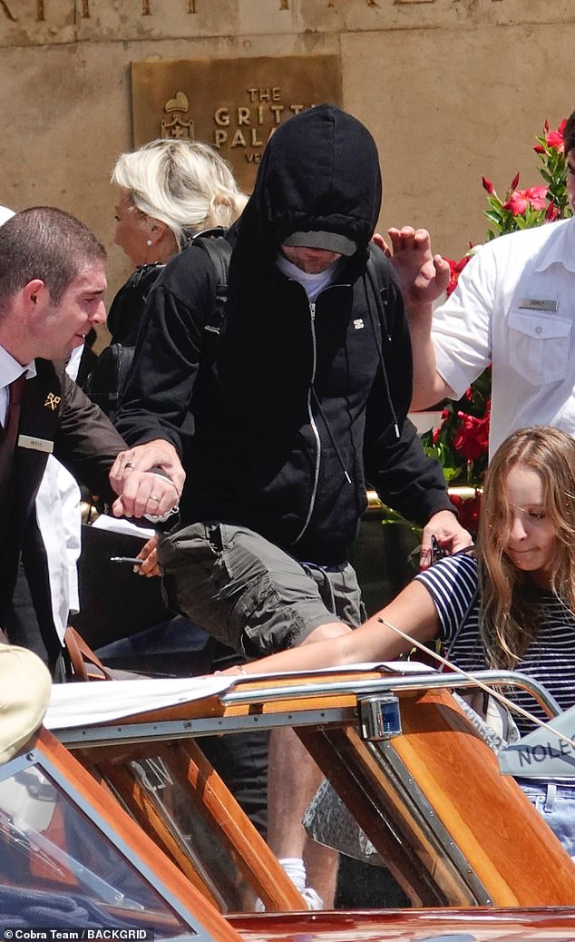 . Climbing into the waiting Venetian water taxi, he hid beneath his trademark low sitting baseball cap and for extra concealment, pulled up his hooded jumper over his head