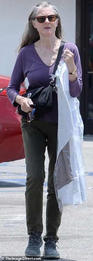 Letting her grey hair tumble freely over her shoulders, she accessorized with tortoiseshell shades and a black cross-body handbag