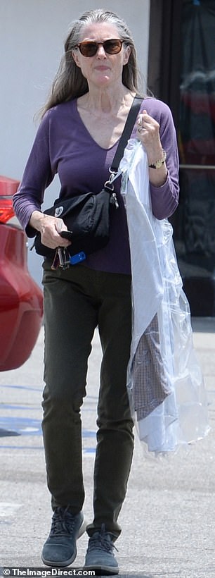 Annette was spotted wearing a stylish ensemble as she collected her dry cleaning and carried it across the parking lot to her car