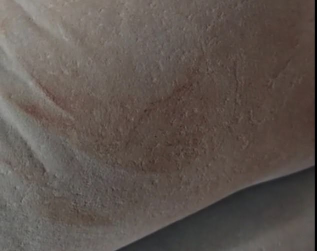 A bloody handprint is also visible on the sofa downstairs, which also contains other streaks of blood