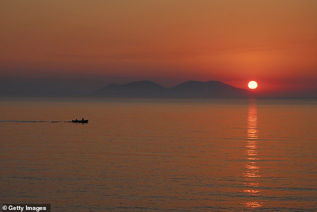 Pictured: The island of Sazan being illuminated by a setting sun