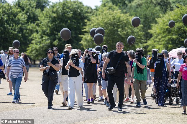 The group, dressed in black veils with 'free your face' printed on them, walked through the park in unison