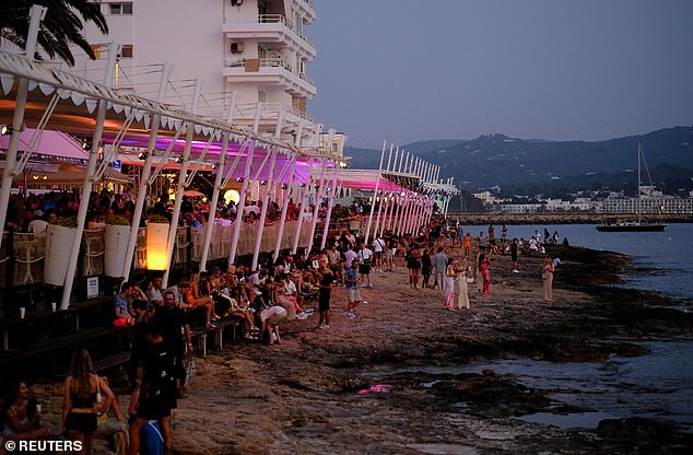The situation has been made worse by the conversion of residential properties into short-term holiday lets, shrinking the supply of long-term rentals. Pictured: Tourists enjoy the sunset in the Sant Antoni de Portmany on the North central coast of Ibiza