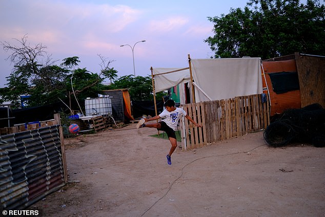 Soaring property prices have caused a housing crisis so severe that many municipal workers ¿ including judges, police officers and medial workers ¿ are now unable to afford to live there. Pictured: Isaias, 11, plays in front of a makeshift settlement called Can Rova 2