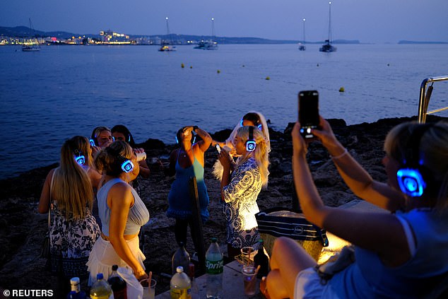 In some cases, holidaymakers arrive on the island to find they have been tricked into paying for non-existent flats or even phantom luxury villas, Gómez Bastida, a former lieutenant colonel in the Civil Guard, said. Pictured: Sunseekers from Britain dance on the beach