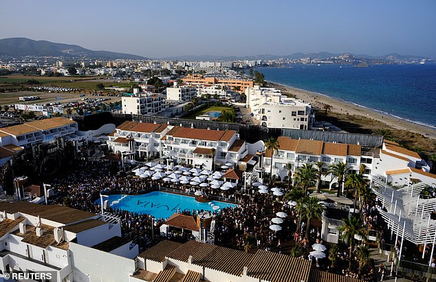Tourists dance inside a discotheque near Playa d'en Bossa beach