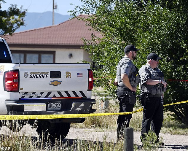 Fremont County deputies guard the road leading to the Return to Nature Funeral Home in Penrose, Colorado in October 2023