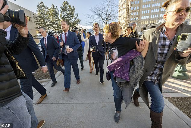 Chrystina Page, right, holds back Heather De Wolf, as she yells at Jon Hallford, left, the owner of Back to Nature Funeral Home, as he leaves with his lawyers following a hearing in February 2024 in Colorado Springs, Colorado