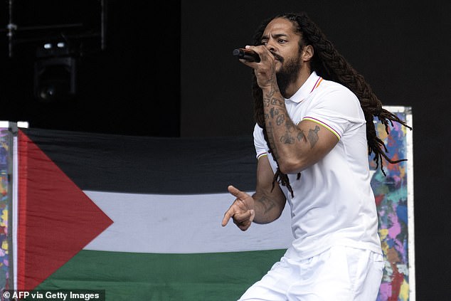 To the backdrop of a Palestinian flag, Bobby Vylan of British duo Bob Vylan performs on the West Holts Stage