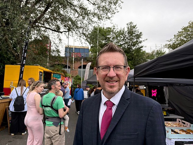 Members of the public quickly noticed his pose and attire were the exact same as a shot of him (pictured) on the other side of his constituency, in Levenshulme, the day before