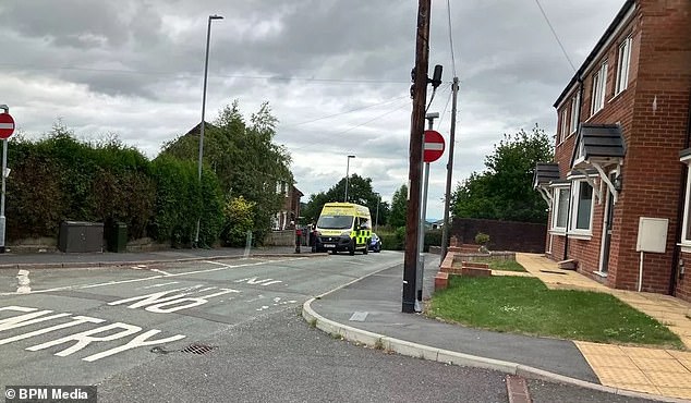 Three uniformed officers and two marked cars with flashing lights were positioned in the entrance to a school, Our Lady of Grace Catholic Academy, locals said