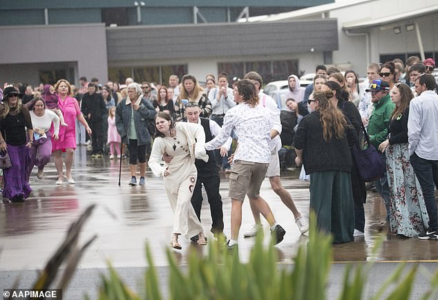 A teenage mourner was seen running after the hearse as it left the funeral service, with two fellow mourners holding her back as a woman runs to help