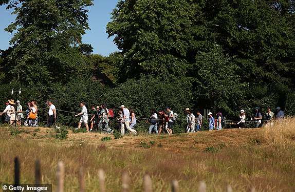 LONDON, ENGLAND - JUNE 30: Spectators queue in the sun on day one of The Championships Wimbledon 2025 at All England Lawn Tennis and Croquet Club on June 30, 2025 in London, England. (Photo by Ezra Shaw/Getty Images)