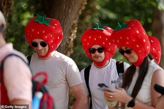 LONDON, ENGLAND - JUNE 30: Spectators queue wearing strawberry hats on day one of The Championships Wimbledon 2025 at All England Lawn Tennis and Croquet Club on June 30, 2025 in London, England. (Photo by Ezra Shaw/Getty Images)
