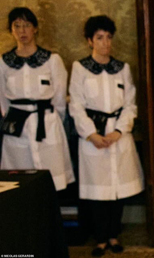 In the background of one of the snaps were two Dolce & Gabanna atelier tailors wearing outfits reminiscent of maid uniforms - consisting of white pinafores with black detailing to the collars and belt ties