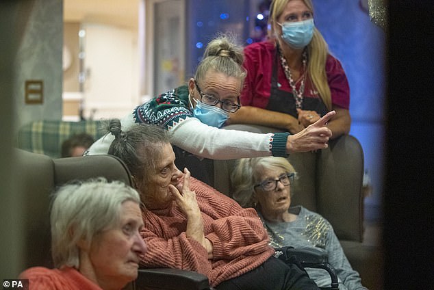 Many care home residents were not able to see friends and family due to lockdown restrictions. Pictured: Residents and care workers at Churchview Nursing Home in Liverpool watch a video of the 2021 Christmas lights switch on in Liverpool city centre