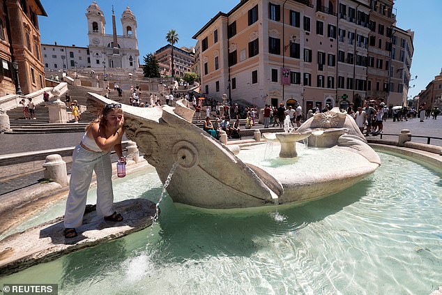 ITALY: The famous Barcaccia fountain comes in handy for one visitor to Rome as temperatures soared on Monday