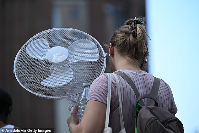 ENGLAND: A shopper in London takes matters into her own hands, bringing a fan along for a sweltering trip to the capital on Monday