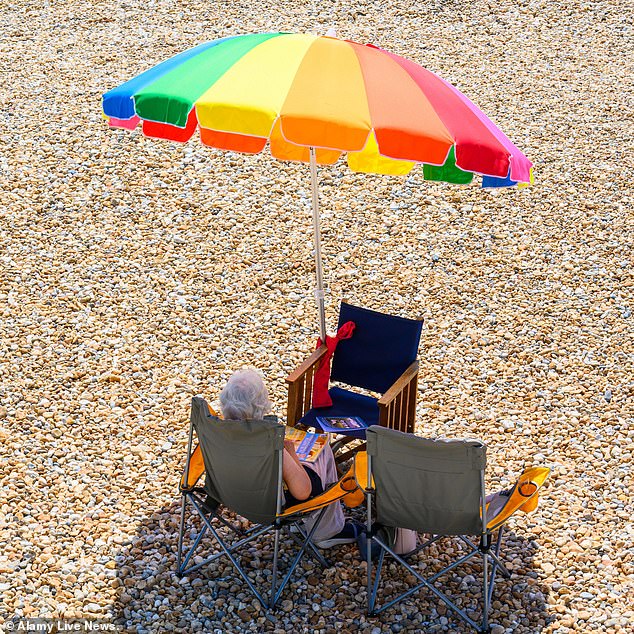 DORSET: Brightly coloured parasols were a mainstay on beaches across the UK today as sunworshippers looked for some time in the shade on Monday