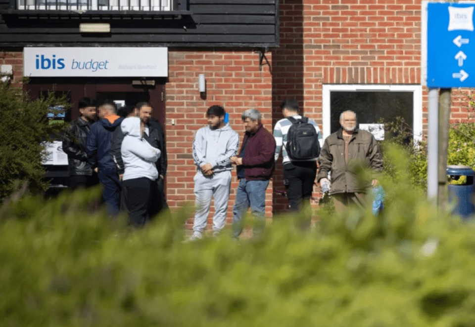 People waiting outside an Ibis Budget hotel.