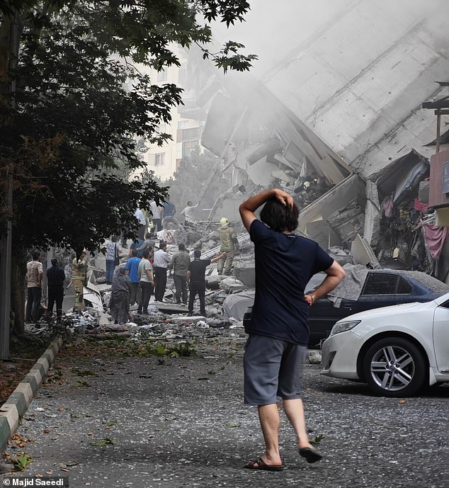 Locals and rescuers look for survivors from a residential building in Tehran hit by Israeli missiles