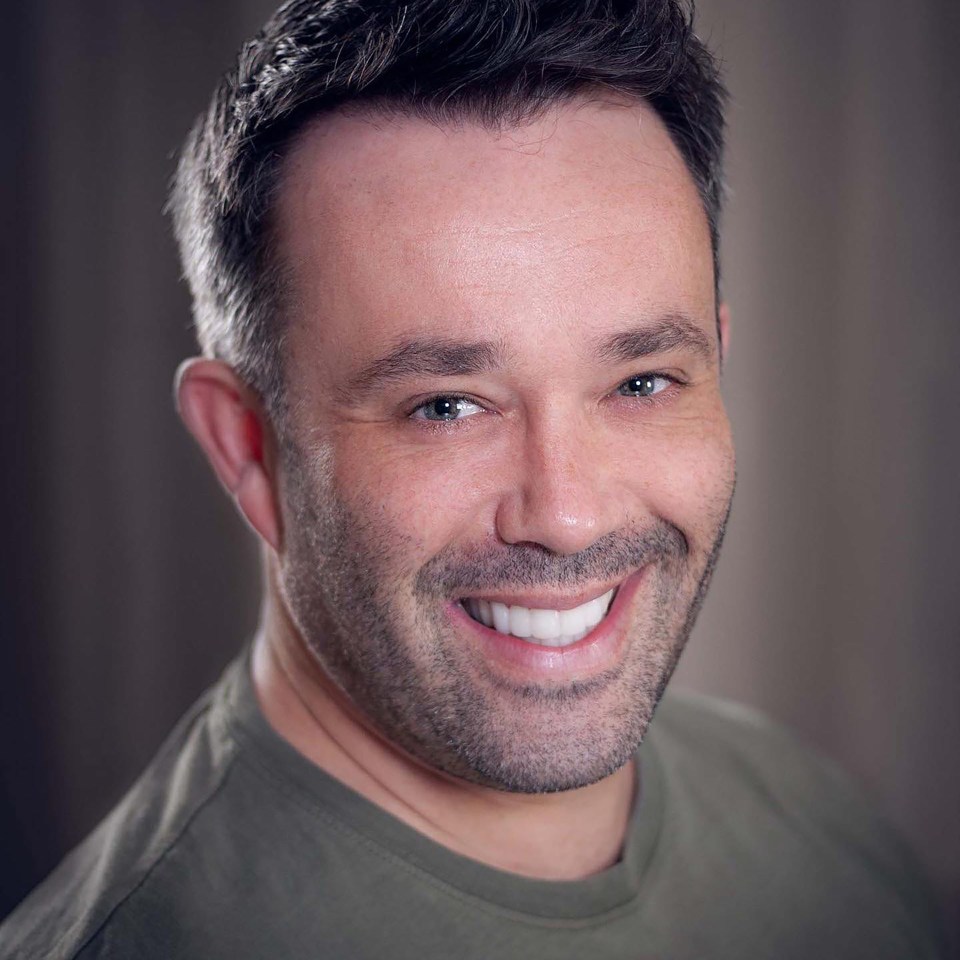 Headshot of a smiling man.