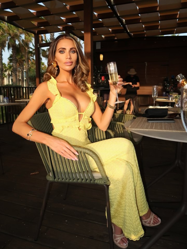 Woman in yellow dress holding a glass of champagne.