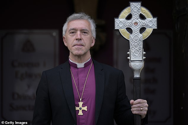 Andrew John poses with the Cross of Wales ahead of the blessing of the cross at Holy Trinity Church, Llandudno on April 19, 2023