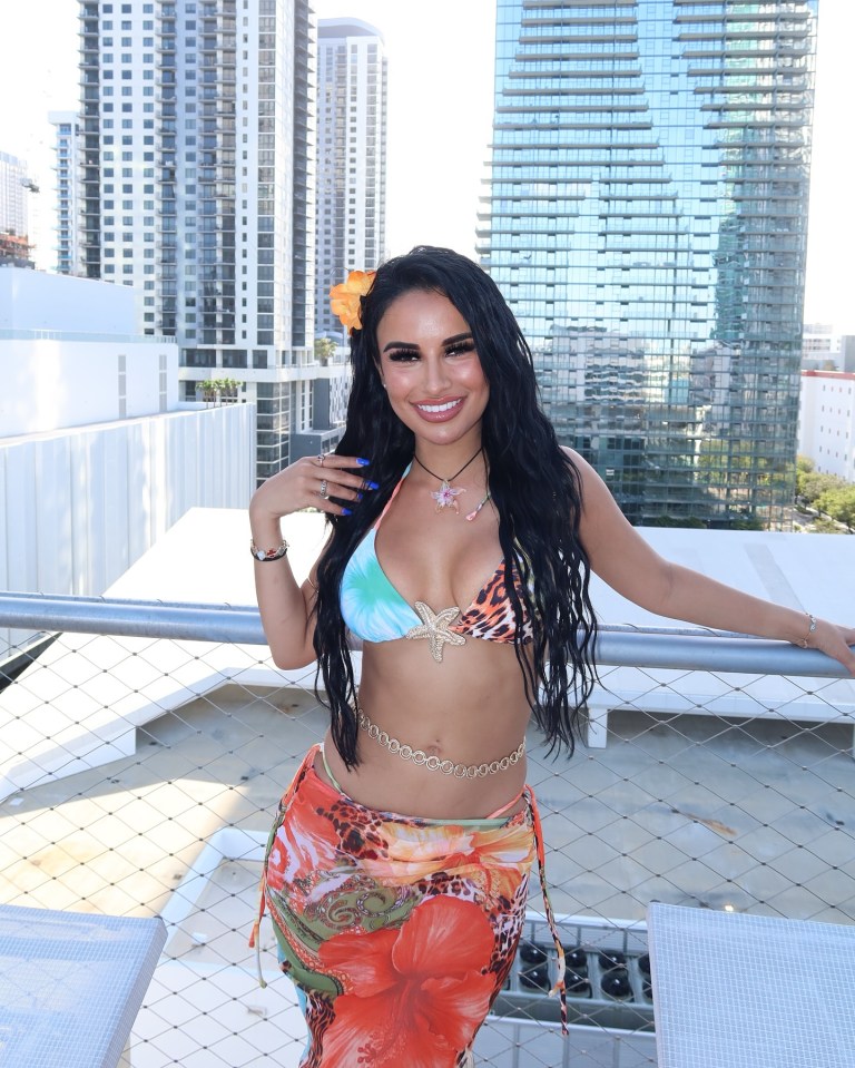 Woman in a swimsuit on a balcony.
