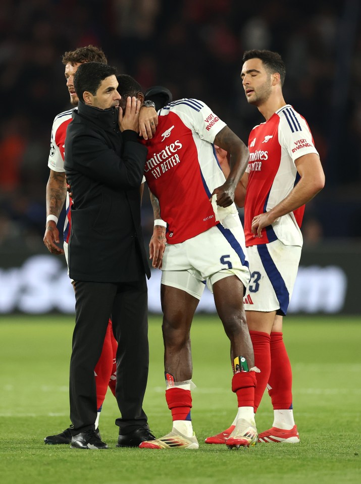 Arsenal's Thomas Partey is consoled by manager Mikel Arteta after a match.