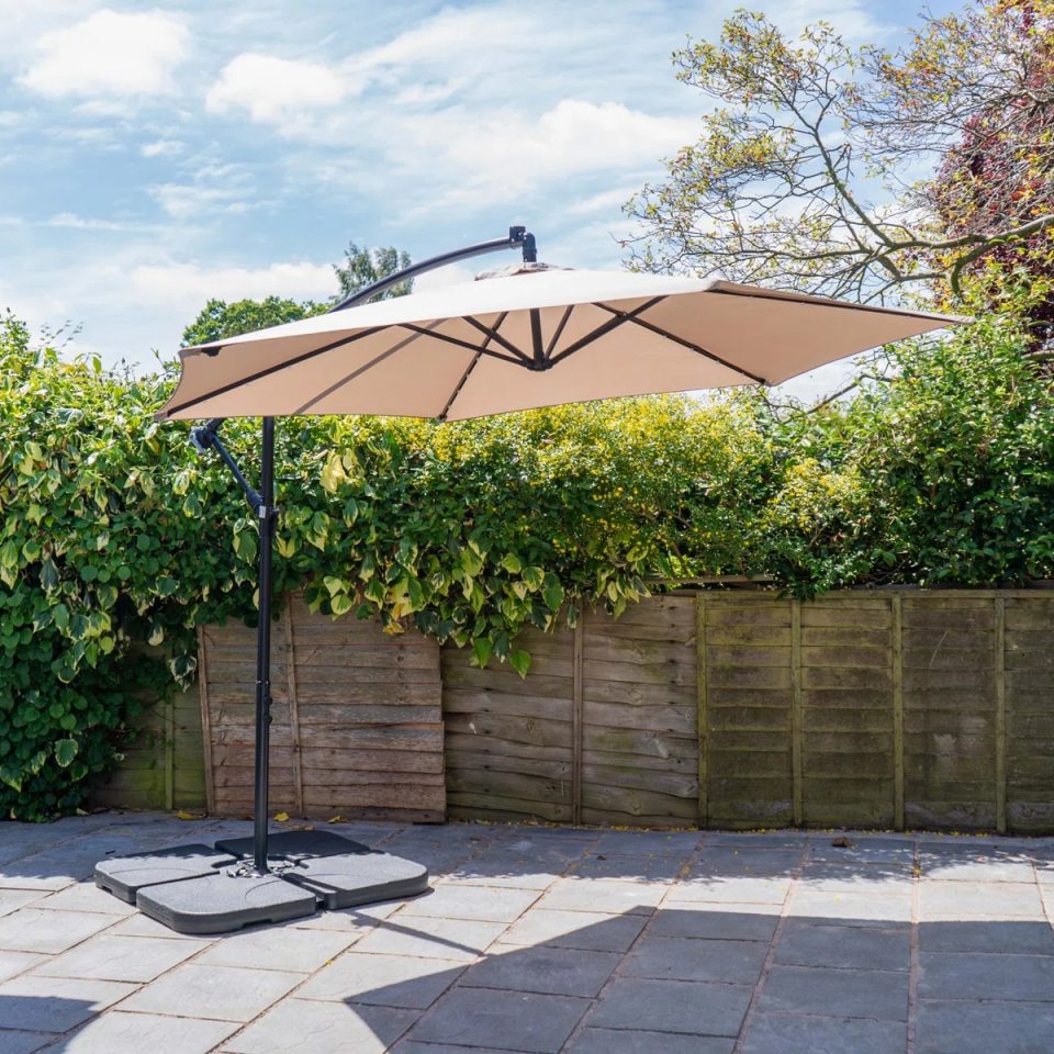 Beige cantilever parasol in a garden.