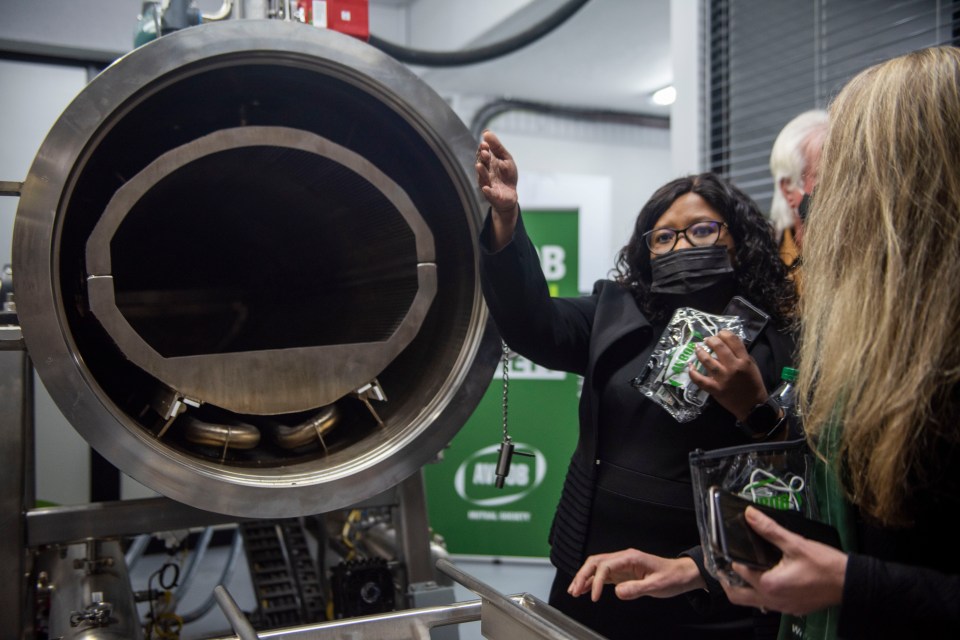 A woman gestures toward an aquamation machine.