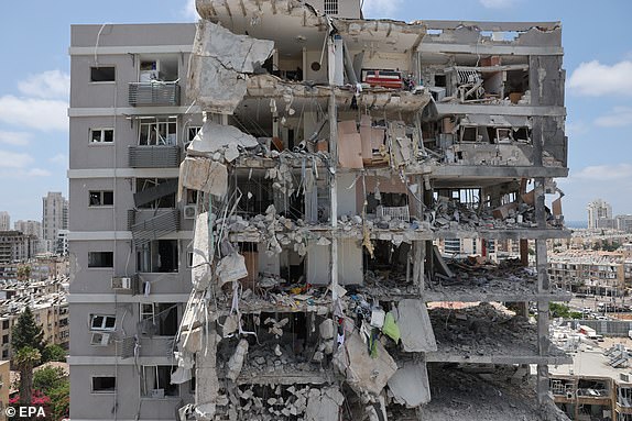 epa12176922 A partially collapsed residential building after Iranian ballistic missiles hit Bat Yam, central Israel, 15 June 2025. Iran launched a barrage of ballistic missiles at Israel overnight in retaliation for Israeli airstrikes on Iranian targets. Magen David Adom (MDA), Israel's national emergency services, reported at least six killed and dozens injured, including two in critical condition.  EPA/ABIR SULTAN