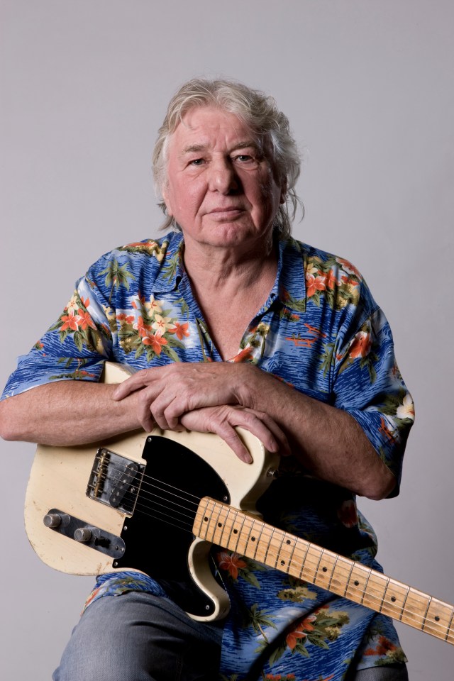 Portrait of Mick Ralphs, British guitarist, holding a guitar.