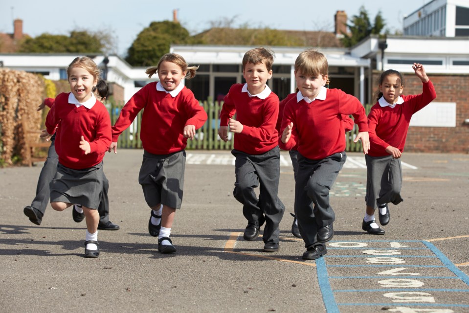 Elementary school children running on a playground.