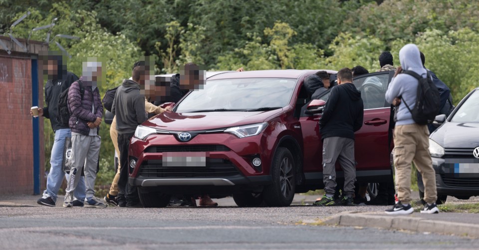 Migrant workers waiting by a car for builders.