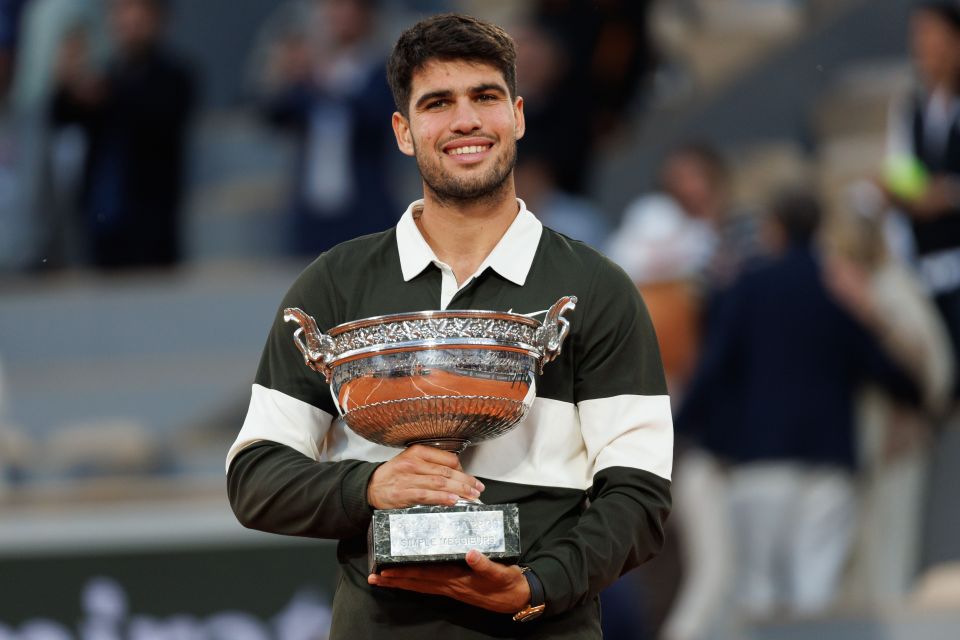 Carlos Alcaraz holding the Roland-Garros trophy.