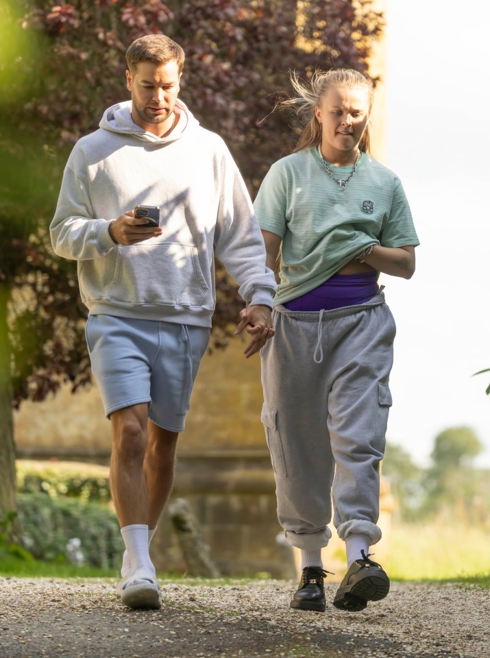 JoJo Siwa and Chris Hughes holding hands and walking.