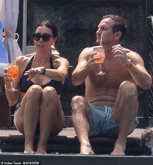 Christine Lampard has displayed her impressive figure in a navy halterneck bikini as she joined her husband Frank in Italy