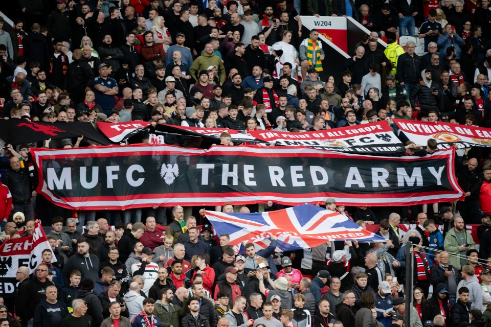 Manchester United fans holding a large banner that reads "MUFC THE RED ARMY".
