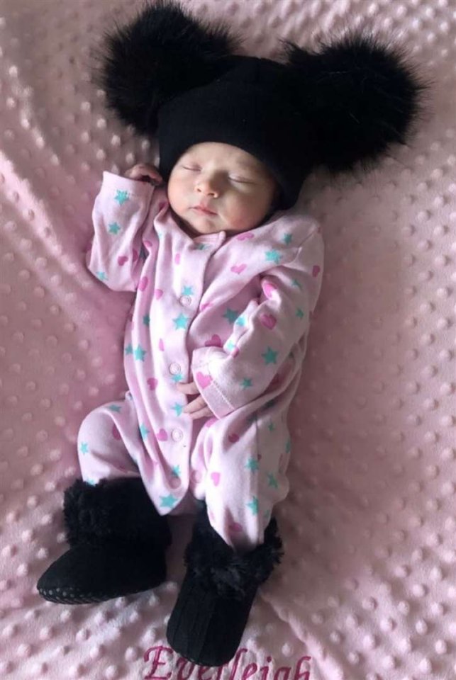 Baby Everleigh Stroud wearing a pink outfit and black hat and booties.
