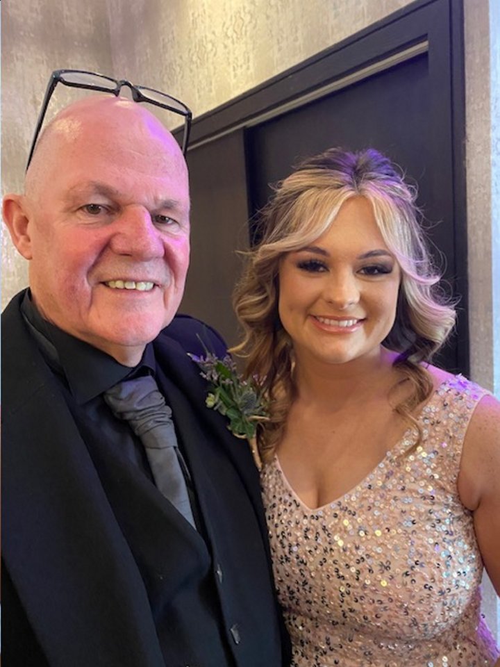 A father and daughter posing for a photo.