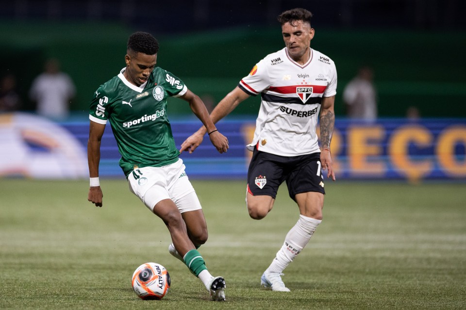 Soccer player in green controlling the ball during a match.
