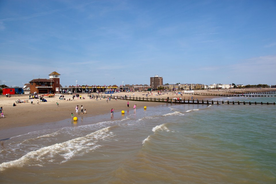 Littlehampton seafront beach with people swimming and playing in the water.