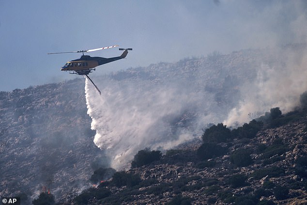 A firefighting helicopter drops water while battling a blaze in the seaside area of Palaia Fokaia, south of Athens, Thursday, June 26, 2025