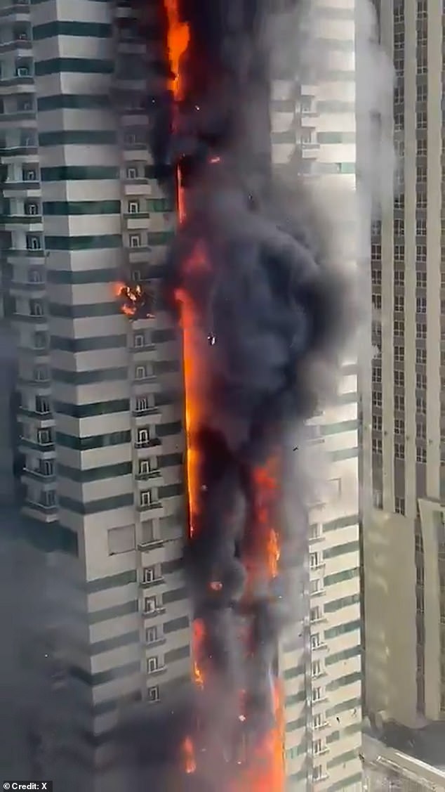 Debris is seen falling from the sky as the 67-storey skyscraper goes up in flames