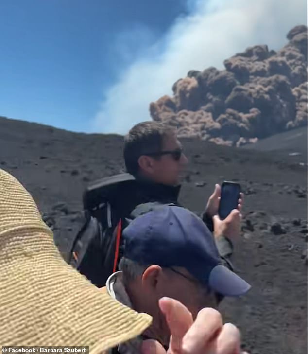 Tourists pause to snap pictures of the huge cloud of volcanic ash